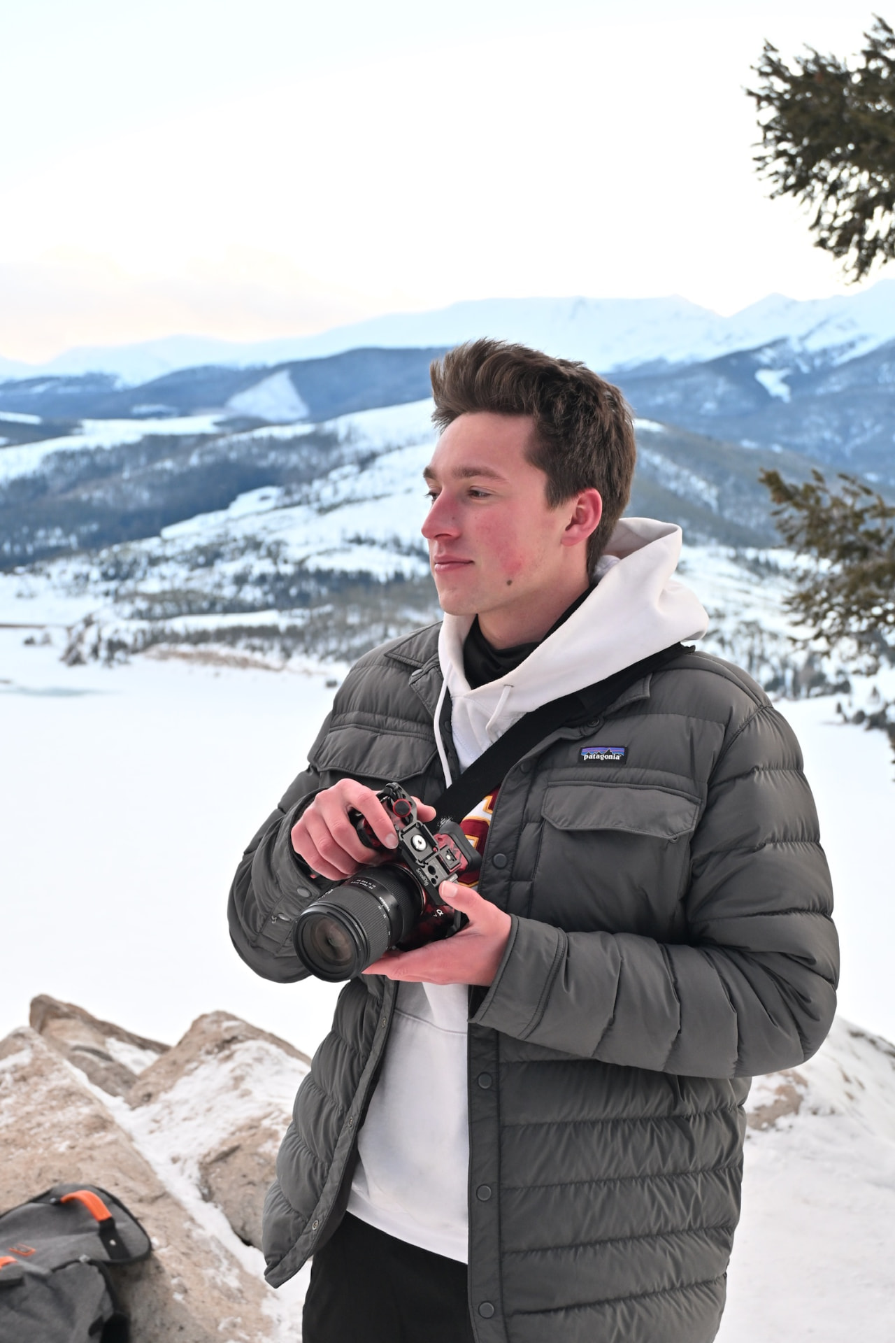 Davis Armstrong on a snowy overlook holding a camera